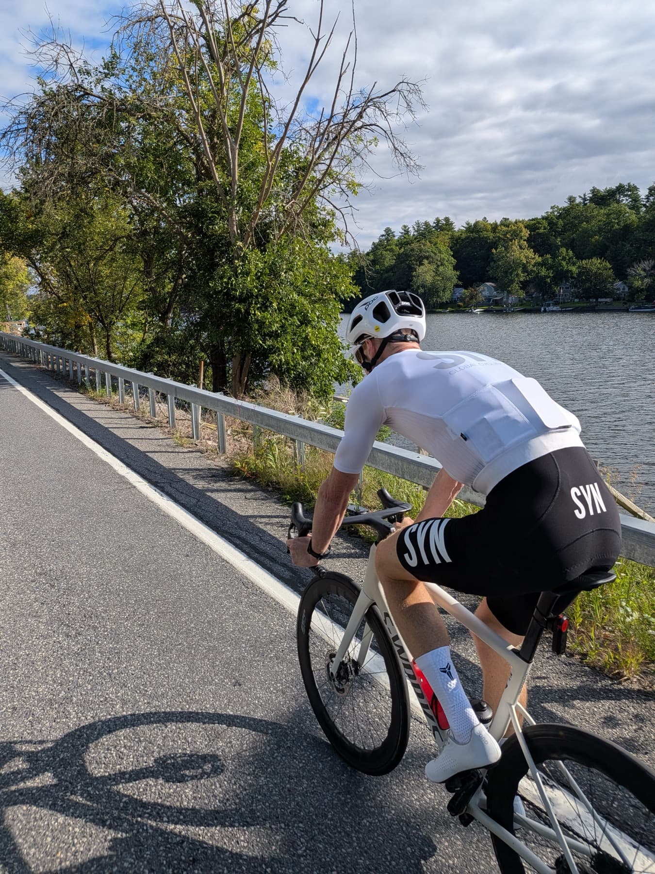 Tyler riding along a lakeside guardrail on the 2026 ride.